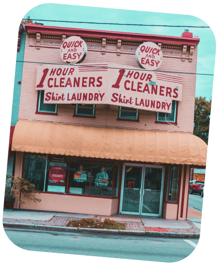 Before Image, blurry storefront of a dry cleaning service with blurry text on the signs